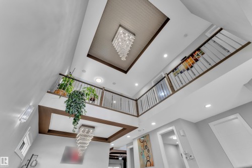 Multi-level interior featuring a grand two-story ceiling, two tiered crystal chandeliers, and recessed lighting - 1404 25 Street, Edmonton, AB - Indoor Photo Showing Other Room