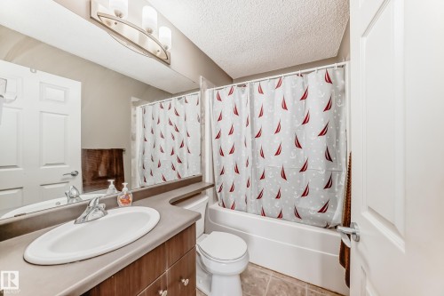 Bathroom featuring a built-in vanity with an oval sink, chrome faucet, and wood-finish cabinetry - 69 3625 144 Avenue, Edmonton, AB - Indoor Photo Showing Bathroom