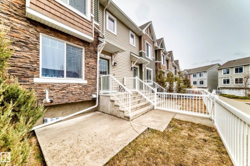 Multi-level residential exterior featuring stacked stone accents, horizontal siding, and a gabled roofline - 69 3625 144 Avenue, Edmonton, AB - Outdoor