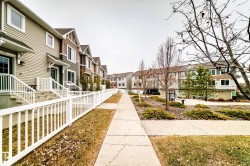 Row of multi-story townhomes featuring varied siding finishes and gabled roofs - 