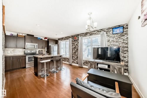 Open-concept kitchen and living area featuring wood-finish flooring - 69 3625 144 Avenue, Edmonton, AB - Indoor
