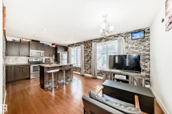 Open-concept kitchen and living area featuring wood-finish flooring - 