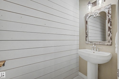 Pedestal sink with chrome faucet, complemented by a distressed decorative mirror - 1110 Armitage Crescent, Edmonton, AB - Indoor Photo Showing Bathroom