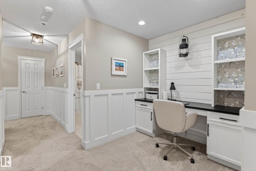 Dedicated workspace featuring a built-in desk with dark countertops and white cabinetry - 1110 Armitage Crescent, Edmonton, AB - Indoor Photo Showing Office