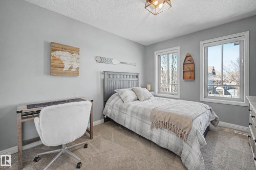 Bright bedroom featuring two large windows and plush carpeting - 1110 Armitage Crescent, Edmonton, AB - Indoor Photo Showing Bedroom