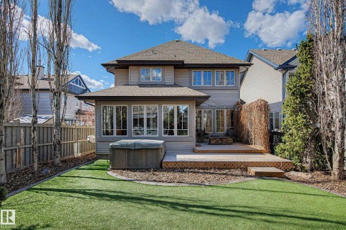 Rear exterior featuring a multi-level wood deck, hot tub, and an artificial turf lawn - 1110 Armitage Crescent, Edmonton, AB - Outdoor With Deck Patio Veranda