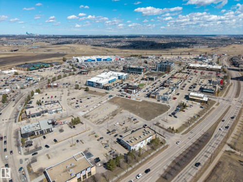 Aerial view showcasing a commercial district with multiple retail buildings, extensive surface parking, and multi-lane roadways - 1110 Armitage Crescent, Edmonton, AB - Outdoor With View