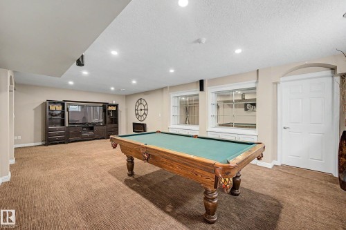 Spacious basement living area featuring recessed lighting, textured carpeting, and integrated wall shelving with cabinetry - 1110 Armitage Crescent, Edmonton, AB 