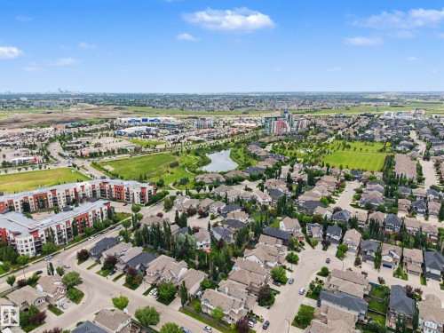 Expansive aerial capturing a residential area with a central pond, surrounding green spaces, and a variety of housing types - 1110 Armitage Crescent, Edmonton, AB 