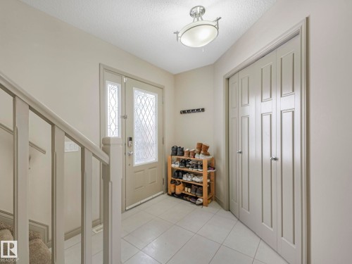 Entryway with decorative glass sidelights and door inserts, accompanied by a bi-fold closet - 21851 80 Avenue, Edmonton, AB - Indoor Photo Showing Other Room