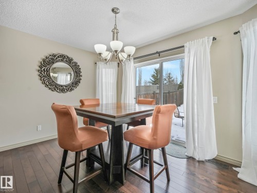 Dining area featuring wood-finish flooring and a contemporary chandelier - 21851 80 Avenue, Edmonton, AB - Indoor Photo Showing Dining Room