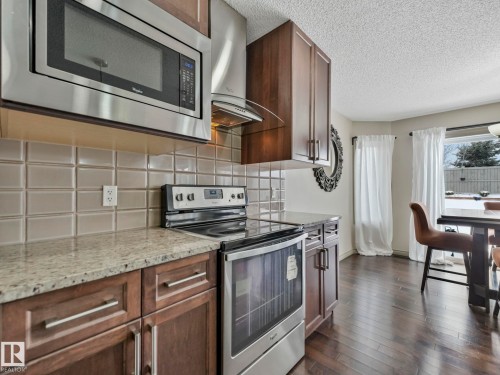 Modern kitchen featuring stainless steel appliances, including a built-in microwave and electric range - 21851 80 Avenue, Edmonton, AB - Indoor Photo Showing Kitchen With Upgraded Kitchen