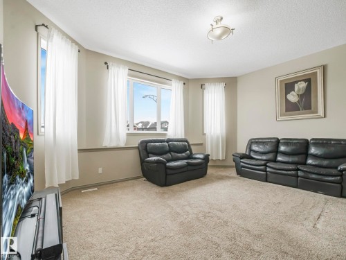 Spacious living area featuring neutral-toned walls, light-colored carpeting, and a bay window - 21851 80 Avenue, Edmonton, AB - Indoor Photo Showing Living Room