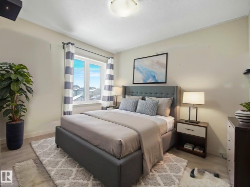 Bright bedroom featuring light-toned walls and wood-finish flooring - 21851 80 Avenue, Edmonton, AB - Indoor Photo Showing Bedroom