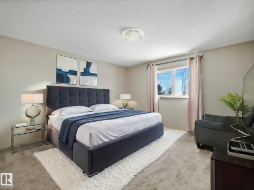Carpeted bedroom featuring a large window, neutral wall tones, and overhead flush-mount lighting - 21851 80 Avenue, Edmonton, AB - Indoor Photo Showing Bedroom