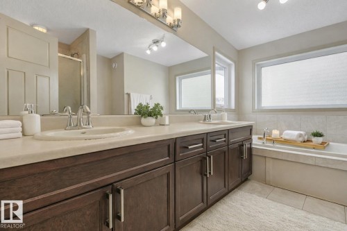 Double vanity with integral sinks and a light-toned countertop - 21851 80 Avenue, Edmonton, AB - Indoor Photo Showing Bathroom