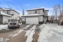 The property features a two-story exterior with light gray siding and dark trim, a white garage door, and a covered front entrance - 112 Lakeland Point(E), Beaumont, AB  - Outdoor With Facade 