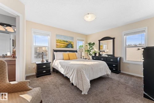 The room features soft cream-colored walls and plush carpeting - 112 Lakeland Point(E), Beaumont, AB - Indoor Photo Showing Bedroom