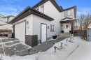The property features light gray siding, a white garage door, and a white front door with a small porch - 112 Lakeland Point(E), Beaumont, AB  - Outdoor 