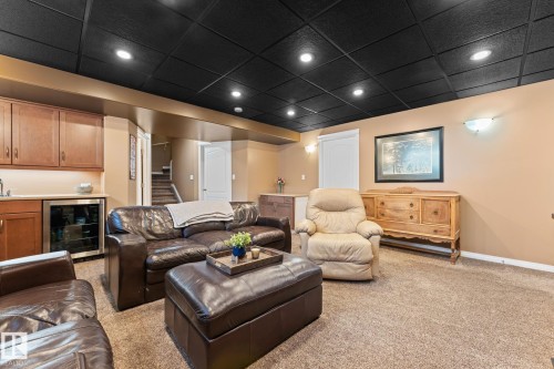 This living area features a dark ceiling with recessed lighting, light-colored walls, and carpeting - 112 Lakeland Point(E), Beaumont, AB - Indoor