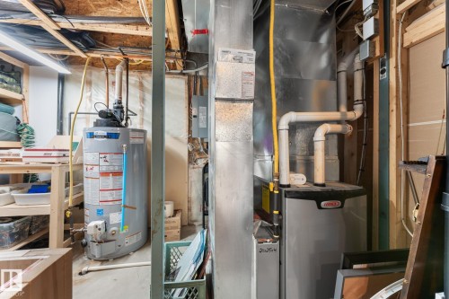 Utility area featuring a water heater and furnace with exposed ductwork - 112 Lakeland Point(E), Beaumont, AB - Indoor Photo Showing Basement