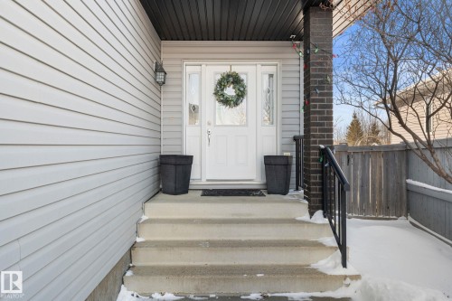 The property features a front entrance with concrete steps, a white door, and light-colored siding - 112 Lakeland Point(E), Beaumont, AB - Outdoor With Exterior