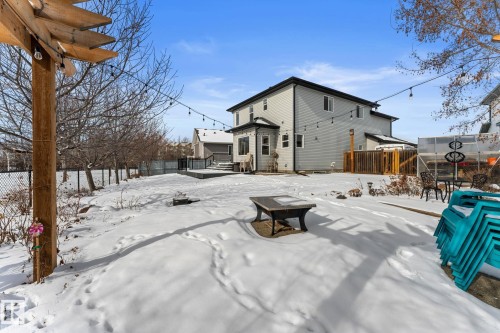 The property features a spacious backyard with a deck, a greenhouse structure, and string lighting - 112 Lakeland Point(E), Beaumont, AB - Outdoor