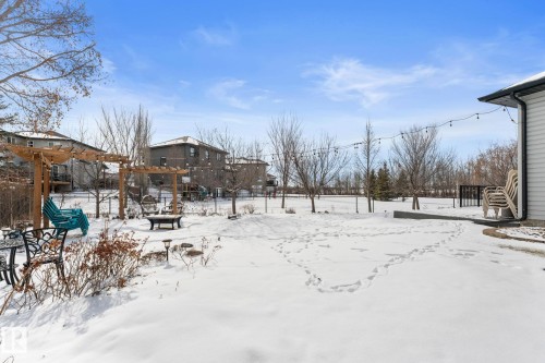 The property features a spacious backyard with a patio area and string lights - 112 Lakeland Point(E), Beaumont, AB - Outdoor