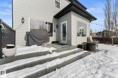 The property features an exterior deck with grey siding and a glass-paned door, offering direct access to the outdoor space - 112 Lakeland Point(E), Beaumont, AB - Outdoor With Exterior