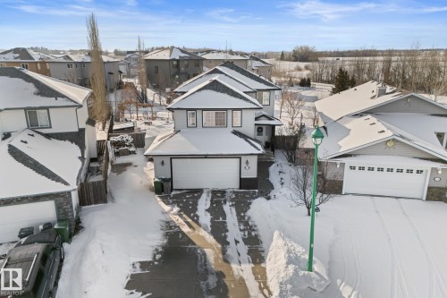 The property features a two-story design with an attached double garage, a paved driveway, and a fenced side yard - 112 Lakeland Point(E), Beaumont, AB - Outdoor