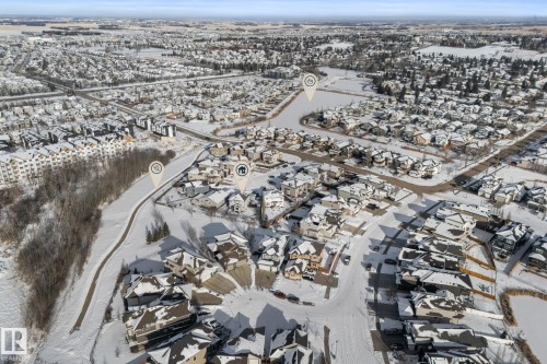 Aerial view showcasing a residential area with varied housing styles, roads, and snow-covered terrain - 112 Lakeland Point(E), Beaumont, AB - Outdoor With View