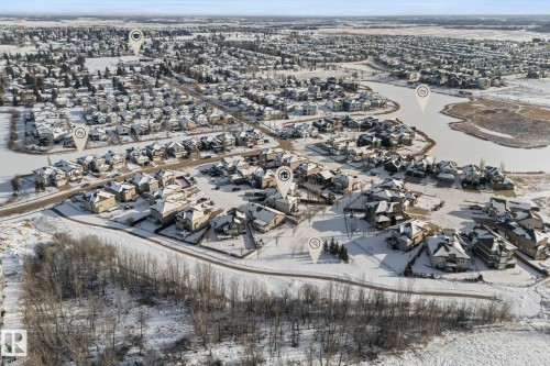 This aerial view showcases a residential area with numerous properties, many featuring snow-covered roofs - 112 Lakeland Point(E), Beaumont, AB - Outdoor With View