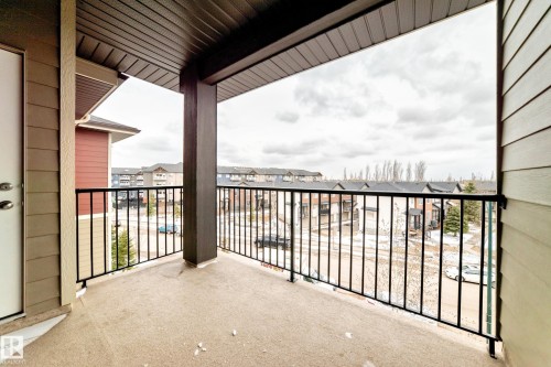 Private outdoor balcony featuring a concrete floor, black metal railings, and a contrasting dark soffit - 404 12025 22 Avenue Sw, Edmonton, AB - Outdoor With Balcony With Exterior