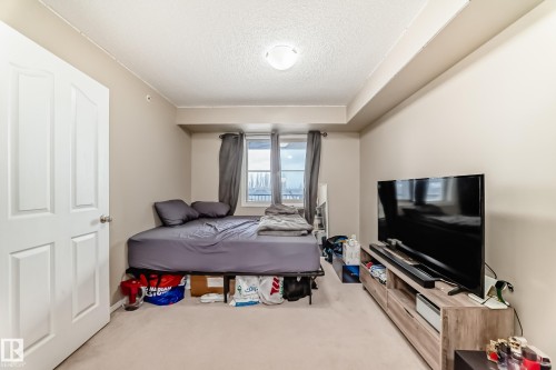 Neutral tone walls featuring carpet flooring and a built-in light fixture - 404 12025 22 Avenue Sw, Edmonton, AB - Indoor