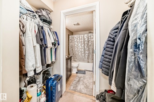 Walk-in closet with integrated wire shelving system and overhead storage - 404 12025 22 Avenue Sw, Edmonton, AB - Indoor With Storage