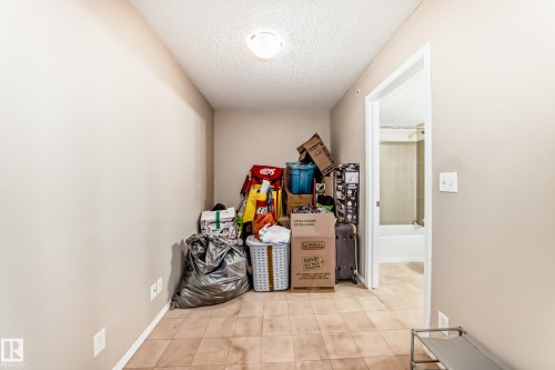 Recessed nook featuring neutral wall paint, textured ceiling, and tile flooring - 404 12025 22 Avenue Sw, Edmonton, AB - Indoor Photo Showing Other Room