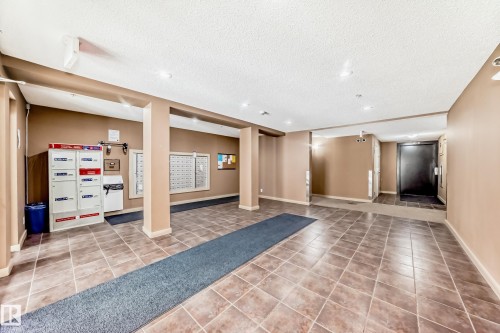 Lobby area featuring tiled flooring, recessed lighting, neutral wall tones, and individual mailboxes - 404 12025 22 Avenue Sw, Edmonton, AB - Indoor