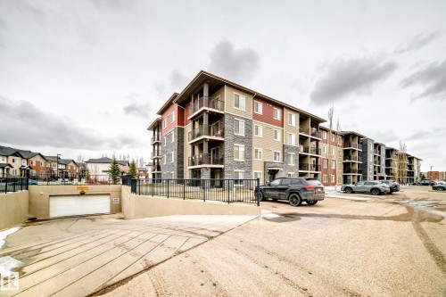Multi-story residential building featuring a stone and siding exterior - 404 12025 22 Avenue Sw, Edmonton, AB - Outdoor With Balcony With Facade