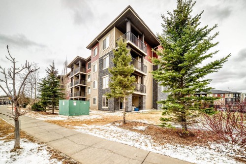 Multistory residential building featuring varied facade materials including horizontal siding and stone veneer - 404 12025 22 Avenue Sw, Edmonton, AB - Outdoor With Balcony