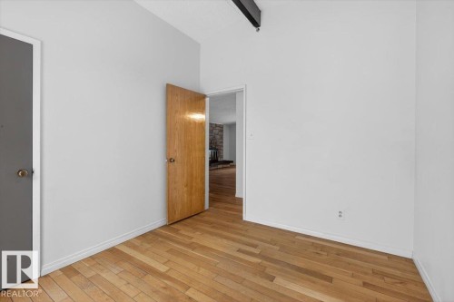 Interior room featuring light-toned walls and wood-finish flooring - 6018 105A Street, Edmonton, AB 