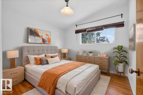 Bedroom featuring wood-finish flooring, a window with horizontal blinds, and a built-in light fixture - 6018 105A Street, Edmonton, AB 