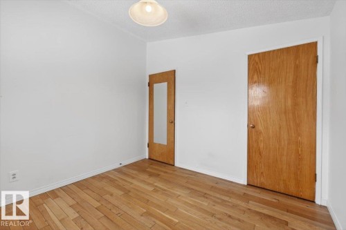 Wood-finish flooring throughout, complemented by white walls - 6018 105A Street, Edmonton, AB 
