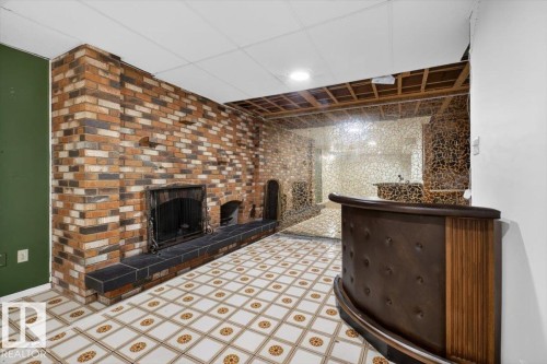 Brick fireplace with a black stone hearth and an integrated wood-finish bar - 6018 105A Street, Edmonton, AB 