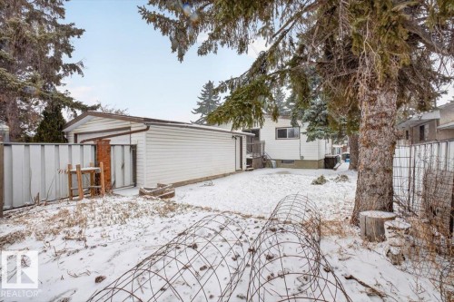 Detached garage structure with white horizontal siding and a brown trim roofline - 6018 105A Street, Edmonton, AB 
