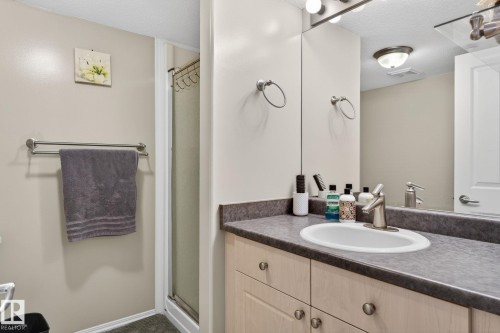 Bathroom featuring a vanity with an integrated sink, a large mirror, and a full shower enclosure - 1904 36 Avenue, Edmonton, AB - Indoor Photo Showing Bathroom