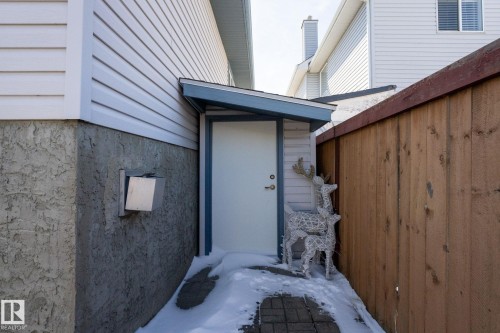 Side entry with white door under a blue-trimmed overhang - 1904 36 Avenue, Edmonton, AB - Outdoor With Exterior
