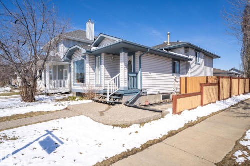 Exterior featuring light-colored siding with blue trim accents and a bay window - 1904 36 Avenue, Edmonton, AB - Outdoor