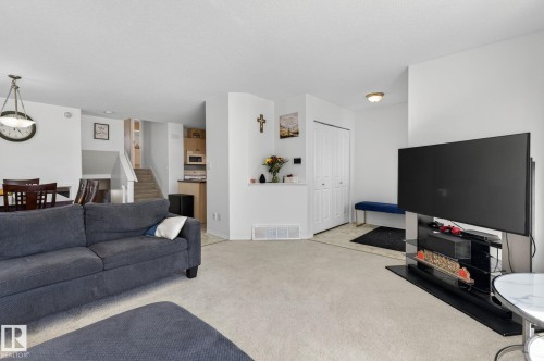 Open-concept living space with light-toned carpeting and neutral wall colors - 1904 36 Avenue, Edmonton, AB - Indoor Photo Showing Living Room