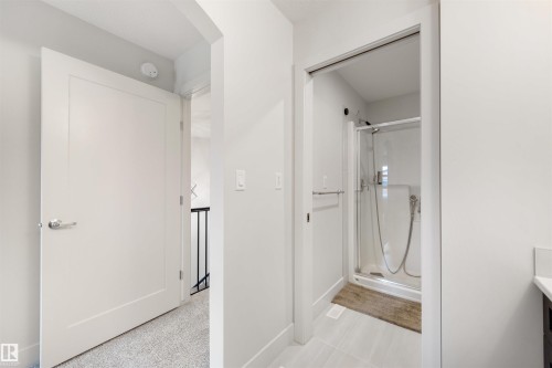 Bathroom featuring a framed glass shower enclosure, a chrome shower head with a handheld sprayer, and light-toned tile flooring - 3193 Checknita Way, Edmonton, AB - Indoor Photo Showing Bathroom
