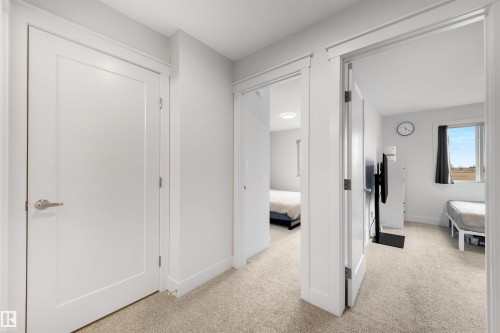 Hallway with light-toned carpet flooring and white trim - 3193 Checknita Way, Edmonton, AB - Indoor Photo Showing Other Room